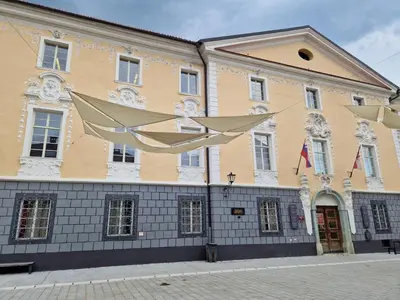 a large yellow and white building on a street at Sobe Lotrist in Radovljica