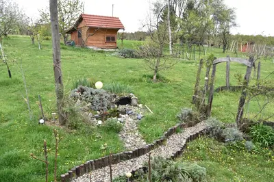a garden with a stone path and a log cabin at Apartment in Grabrovec - Koroska Unterkärnten 44968 in Metlika