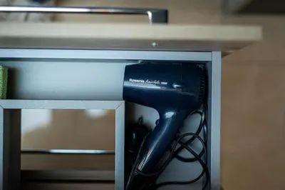a black hairdryer in a drawer in a table at Panorama in Bohinj