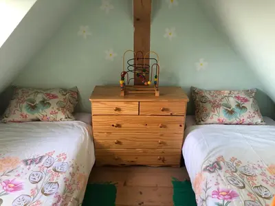 a bedroom with two beds and a wooden dresser at Vineyard Cottage Janko & Metka in Otočec