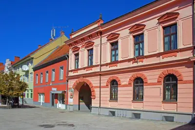 a large brick building with an arch in a street at Podhamer Wellness Vineyard Cottages in Ljutomer