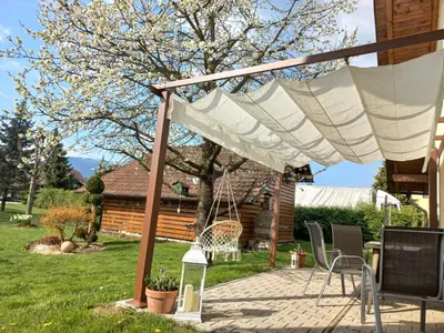 a pergola with chairs and a table in a yard at Apartment Joga in Rečica ob Savinji