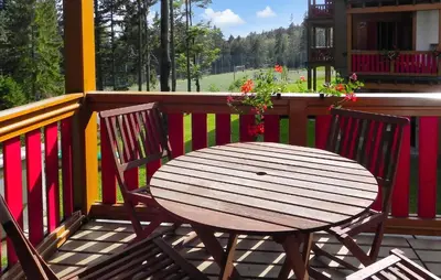 a wooden table and two chairs on a porch at 2 Bedroom Awesome Apartment In Pohorje in Pohorje