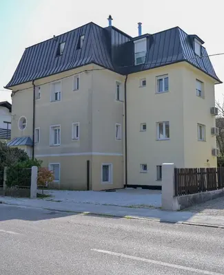 a large white building with a black roof at YELLOW APARTMENT WITH FREE PARKING in Ljubljana