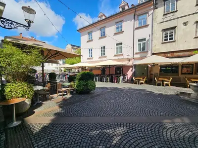 a cobblestone street with tables and chairs and a building at Studio Apartment Sviti TourAs by Town Hall in Ljubljana