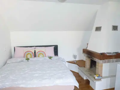 a bedroom with a bed with a rainbow pillow and a piano at Holiday home in Dragatus - Kranjska (Krain) 50798 in Dragatuš