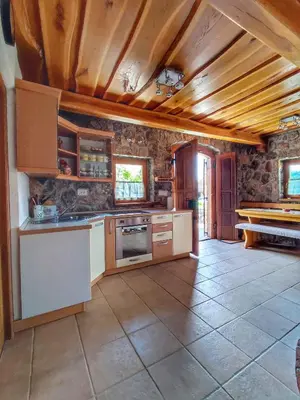 a large kitchen with stone walls and wooden ceilings at Holiday home in Dolenjske Toplice - Kranjska (Krain) 51092 in Dolenjske Toplice