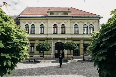 a woman walking in front of a building at Villa Elizabeth - Apartment with Garden in Slovenj Gradec