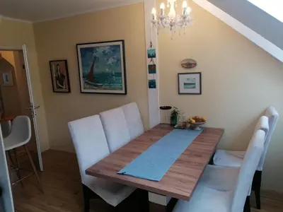 a dining room with a wooden table and white chairs at Unique apartma in the city center in Ljubljana