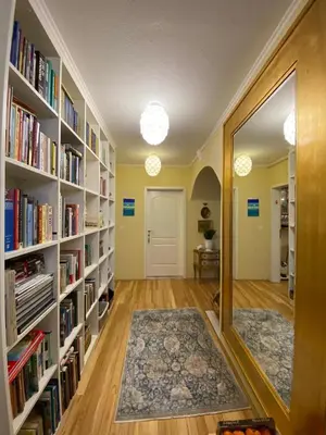a hallway with shelves of books and a mirror at Unique apartma in the city center in Ljubljana