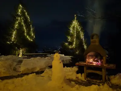 a snowman and a child in front of christmas trees at apartma Pohorc - Macesen in Pohorje