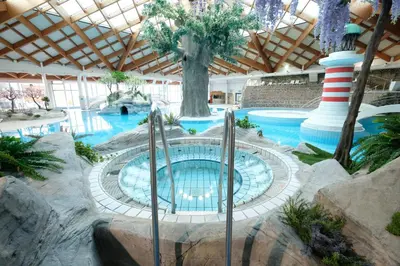 a swimming pool in a resort with a large building at Holiday home Isabella in Terme Čatež in Čatež ob Savi