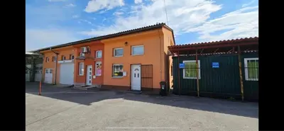 an orange building with two garages in a parking lot at Industrial vibe flat in Ljubljana