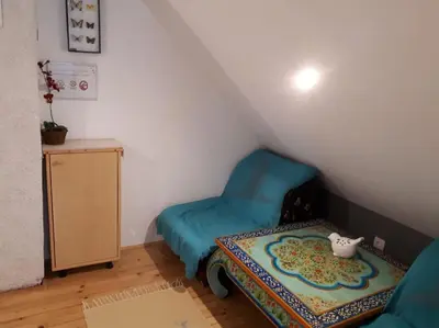 a small room with a blue chair and a table at Cottage Stela, family moutain hideout in Bohinj