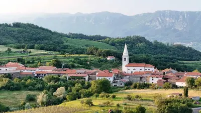 a town in a valley with a church and mountains at Tranquil Escape in Vipava