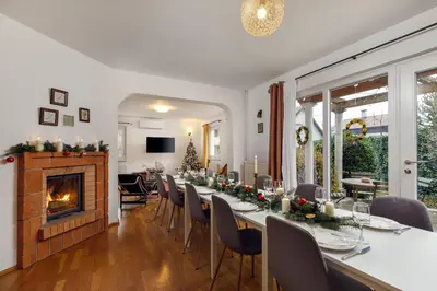 a dining room with a long table and a fireplace at Cozy house close to Ljubljana center in Ljubljana