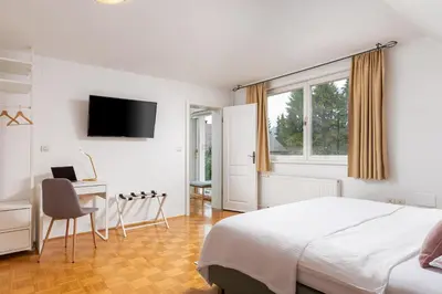a bedroom with a bed and a desk and a television at Cozy house close to Ljubljana center in Ljubljana