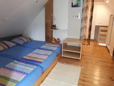 a bedroom with a blue bed and a table at Cottage Stela Bohinj in Bohinj