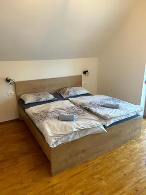 a large bed in a room with a wooden floor at Borl Apartment in Gradišča