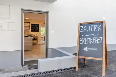 a sign in front of a building with a restaurant at Penzion Hosnar, apartma Mucho in Bovec