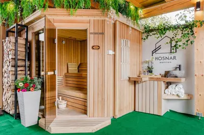 a wooden house with a green floor and plants at Penzion Hosnar, apartma Mucho in Bovec