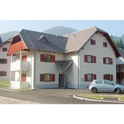 a house with a car parked in front of it at Apartment Harper in Bohinj