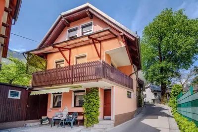 a house with a balcony and a table and chairs at Apartma Vučič in Bovec