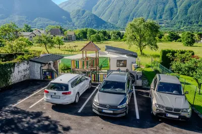 two cars parked in a parking lot with mountains in the background at Penzion Hosnar in Bovec