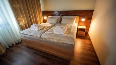 a bedroom with a large bed with white sheets and pillows at Hiša na Hribu- A Peaceful Hilltop Escape above river Kolpa in Kostel
