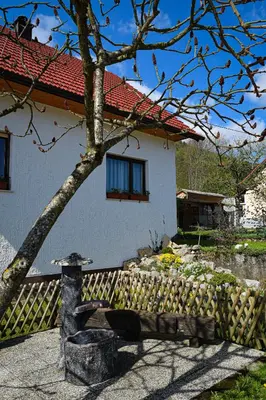 a house with a fence and a bench in front of it at Grajski kamp - pitch your own tent in Kočevje