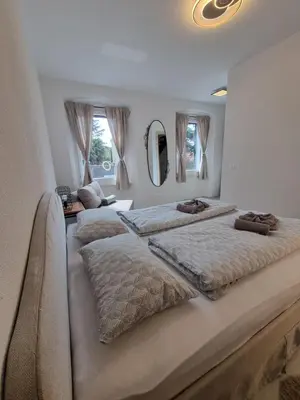 a bedroom with two beds and two mirrors at Rozalija house - Počitniška hiša z vrtom ob reki Soči v Solkanu in Solkan