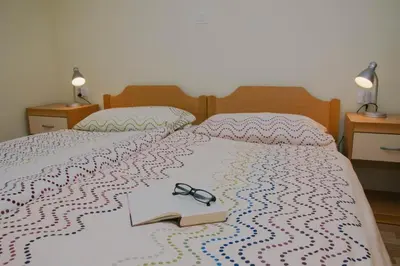 a bed with a book and glasses on it at Apartma Lovriž in Kobarid