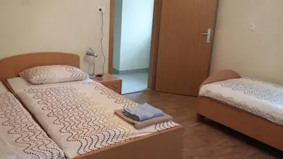 a small bedroom with two beds and a lamp at Apartma Lovriž in Kobarid