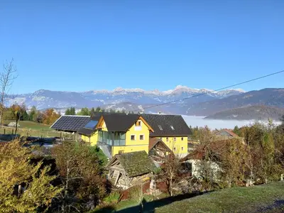 a yellow house with solar panels on top of it at Tubej apartments in Bohinj