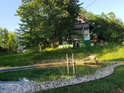 a house on the side of a hill with a pond at Holiday home with 2 bedrooms in Zgornja Kungota