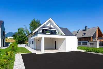 a large white house with a garage at Sunny Green Escape in Lesce