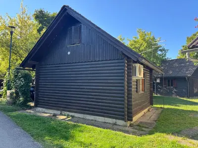 a small brown building with a black roof at Holzhaus in der Therme Čatež - familienfreundlich, Nähe WinterSommerRiviera in Brežice