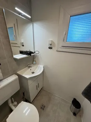 a bathroom with a white toilet and a sink at Holzhaus in der Therme Čatež - familienfreundlich, Nähe WinterSommerRiviera in Brežice