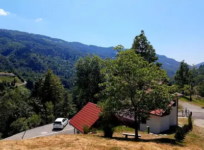 a car parked next to a house with a red roof at Bungalov Čuk in Most na Soči