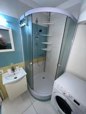 a bathroom with a shower and a sink and a washing machine at CC Vič in Ljubljana