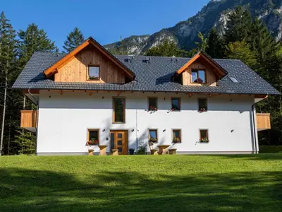 a white house with a wooden roof at The Woodland Nook Apartments Bohinj - One Bedroom Apartment with Balcony in Bohinj