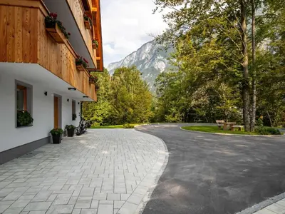 a winding road with a mountain in the background at The Woodland Nook Apartments Bohinj - Two Bedroom Apartment with Balcony in Bohinj