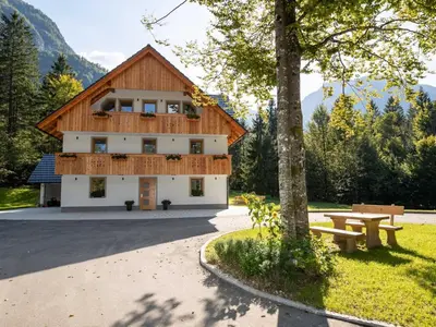 a building with a picnic table in front of it at The Woodland Nook Apartments Bohinj - Two Bedroom Apartment with Balcony in Bohinj