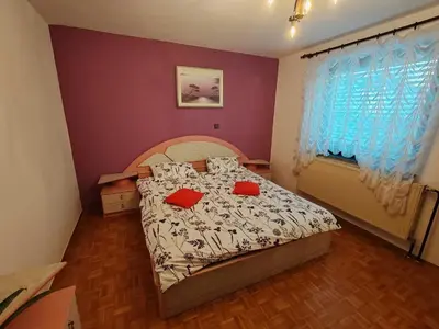 a bedroom with a bed with red pillows on it at Brezovica Spacious Family-Friendy Apartment - Two Bedroom Apartment with Balcony in Smarjeske Toplice