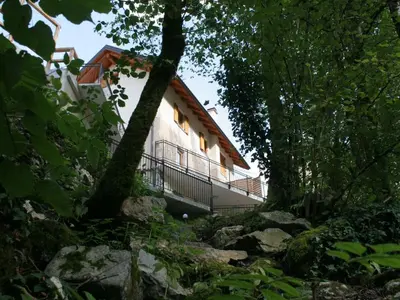 a building in the middle of a forest at Riverside Rustic Ridge Apartments with Balcony - Three Bedroom Apartment with Balcony in Slappe dʼIdria