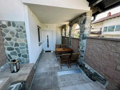a patio with a stone wall and a table and chairs at Modern and Peaceful Apartment with Terrace - Two Bedroom Apartment with Terrace in Rečica ob Savinji