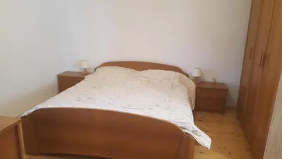 a bed in a room with two night stands and two tables at Kraska hisa in Komen