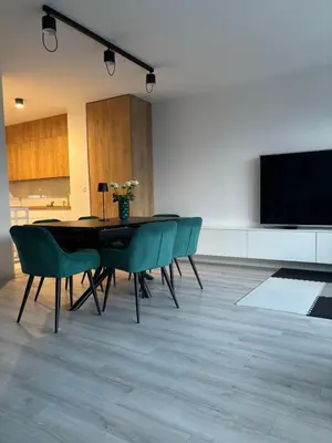 a dining room with a table and chairs and a flat screen tv at Cosy house with sauna and jacuzzi in Miklavž na Dravskem Polju