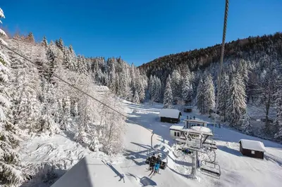 a group of people on a ski lift in the snow at APARTMENTS ROGLA JURGOVO - Ski in Ski out in Lukanja