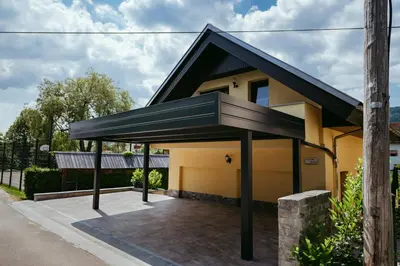 a detached house with a black roof at Apartment Oddih in Bled